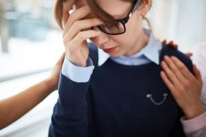 Depressed girl hiding her face by hand